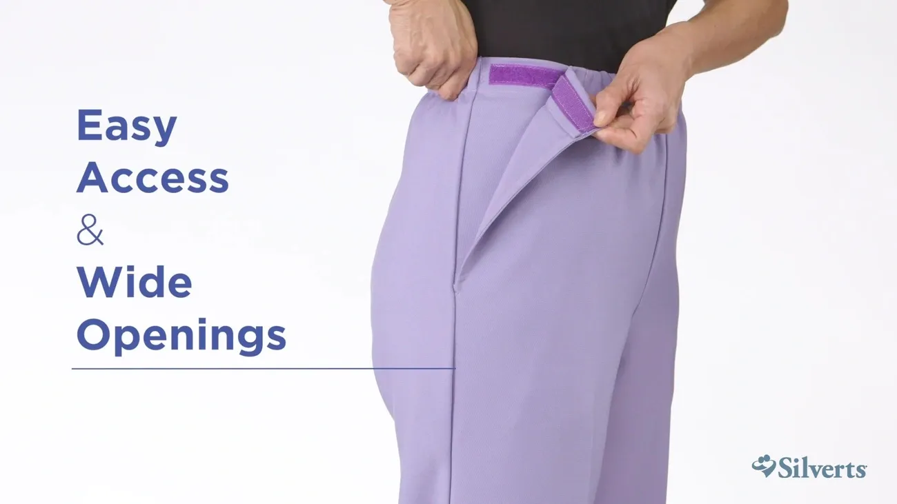 Hands demonstrating easy access and wide openings of lavender adaptive pants with Velcro closure by Silverts.
